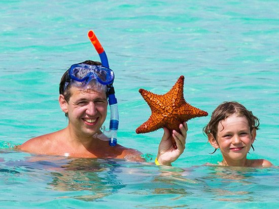 Father and son holding large starfish